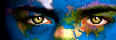 Portrait of a boy with the map of the world painted on his face.